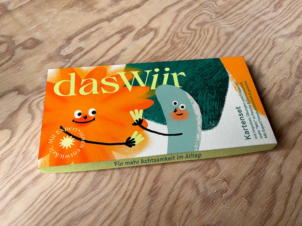 Kartenset-Schachtel „Für mehr Achtsamkeit im Alltag“ auf einer Holzplatte