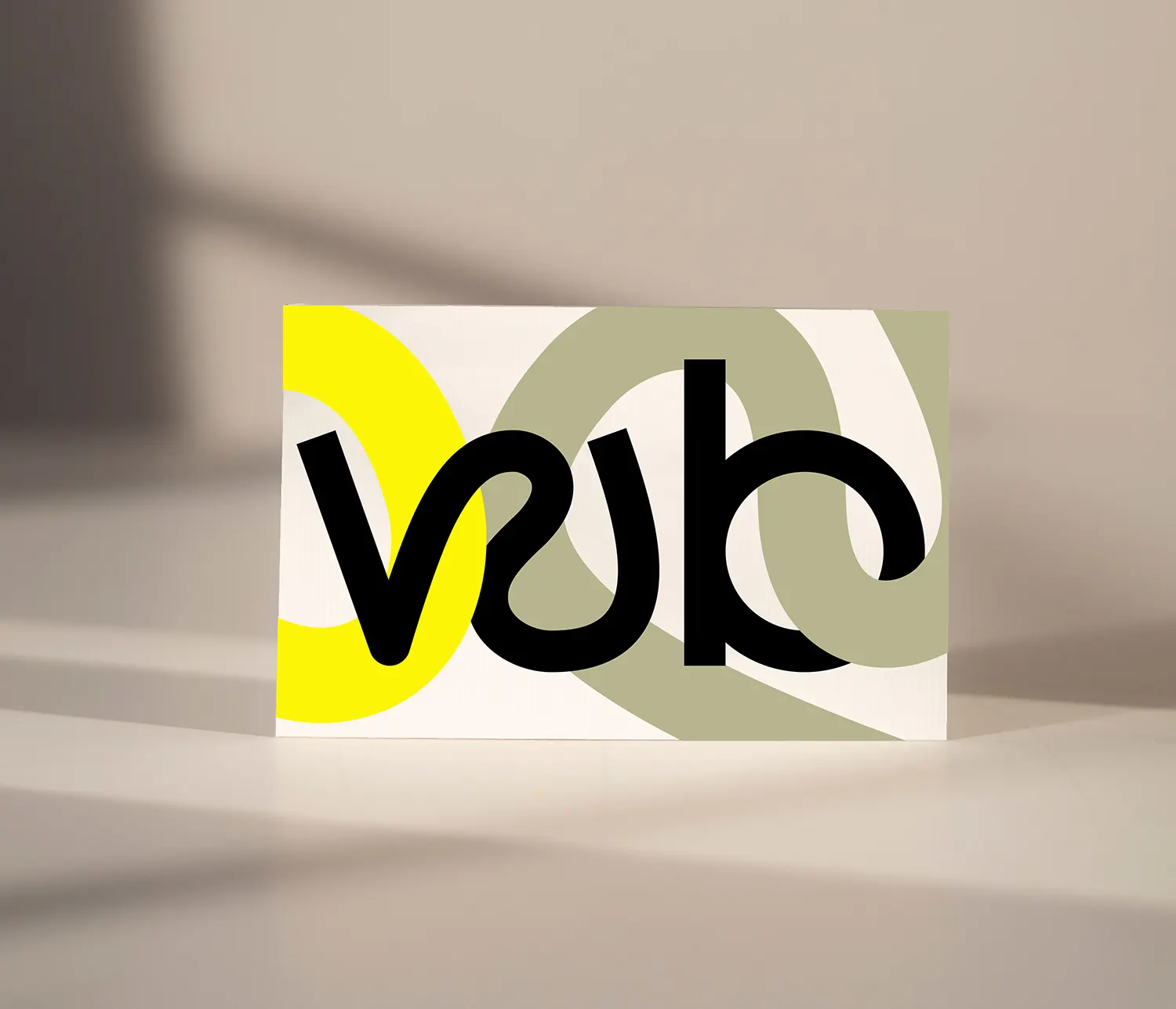 Karte mit dem Monogramm „wb“ vor gelben und olivgrünen Bogenformen